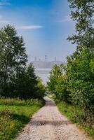 Grün Dorf in der Nähe von Fabrik mit hoch emittieren Schornsteine auf ein Sommer- Tag foto