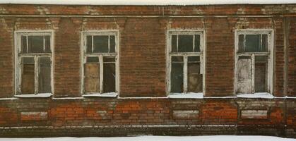 Eine alte Backsteinmauer eines Mehrfamilienhauses mit vielen vernagelten Fenstern ohne Glas foto