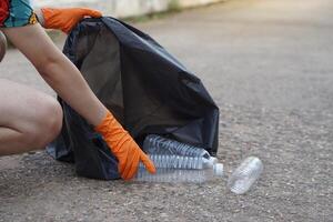 Nahansicht Hand tragen Handschuhe, halt Plastik Flasche. Konzept, Müll Management, wiederverwendet, recycelt Plastik Flaschen. behalten sauber und Gemeinschaft Bedienung zum das Beste Umfeld. Null Abfall. foto