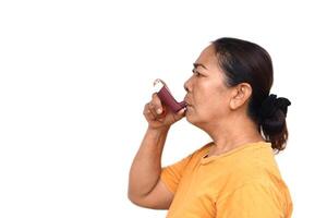 weiblich Senior geduldig Verwendet braun Asthma Inhalator zum Linderung Asthma. Konzept, Gesundheit Pflege beim heim. pharmazeutische Produkte zum Behandlung Symptome von Asthma oder copd. verwenden unter Rezept von Arzt. foto