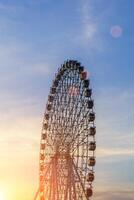 hoch Ferris Rad beim Sonnenuntergang oder Sonnenaufgang mit wolkig Himmel Hintergrund. foto