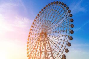 hoch Ferris Rad beim Sonnenuntergang oder Sonnenaufgang mit wolkig Himmel Hintergrund. foto