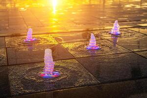 klein Brunnen auf das Bürgersteig, beleuchtet durch Sonnenlicht beim Sonnenuntergang oder Sonnenaufgang beim Sommer. foto