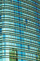 Fragment von ein modern Büro Gebäude. abstrakt geometrisch Hintergrund. Teil von ein Wolkenkratzer mit Glas Fenster. foto