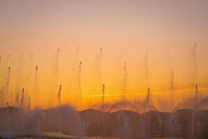 groß Brunnen auf das künstlich Teich, beleuchtet durch Sonnenlicht beim Sonnenuntergang im Taschkent Stadt Park beim Sommer. foto