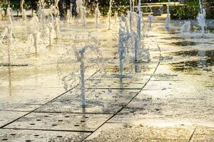 klein Brunnen auf das Bürgersteig, beleuchtet durch Sonnenlicht beim Sonnenuntergang oder Sonnenaufgang beim Sommer. foto