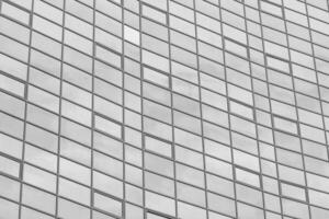 schwarz und Weiß Fragment von ein modern Büro Gebäude. abstrakt geometrisch Hintergrund. Teil von das Fassade von ein Wolkenkratzer mit Glas Fenster. foto