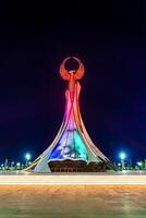 Usbekistan, Taschkent - - April 25, 2023 beleuchtet Monument von Unabhängigkeit im das bilden von ein Stele mit ein Humo Vogel im das Neu Usbekistan Park beim nachts. foto