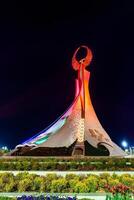 Usbekistan, Taschkent - - April 25, 2023 beleuchtet Monument von Unabhängigkeit im das bilden von ein Stele mit ein Humo Vogel im das Neu Usbekistan Park beim nachts. foto