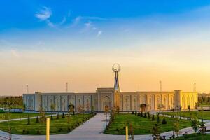 Usbekistan, Taschkent - - April 25, 2023 das Gebiet von das Park Neu Usbekistan mit Monument von Unabhängigkeit im das bilden von ein Stele mit ein Humo Vogel beim Dämmerung. foto