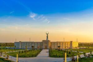 Usbekistan, Taschkent - - April 25, 2023 das Gebiet von das Park Neu Usbekistan mit Monument von Unabhängigkeit im das bilden von ein Stele mit ein Humo Vogel beim Dämmerung. foto