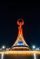 Usbekistan, Taschkent - - April 25, 2023 beleuchtet Monument von Unabhängigkeit im das bilden von ein Stele mit ein Humo Vogel im das Neu Usbekistan Park beim nachts. foto