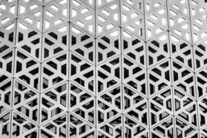 das Textur von das Verkleidung von ein Gebäude gemacht von Metall Aluminium Paneele mit ein geschnitzt Muster. abstrakt Hintergrund. schwarz und Weiß. foto