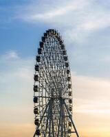 hoch Ferris Rad beim Sonnenuntergang oder Sonnenaufgang mit wolkig Himmel Hintergrund. foto