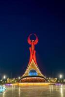 Usbekistan, Taschkent - - kann 5, 2023 beleuchtet Monument von Unabhängigkeit im das bilden von ein Stele mit ein Humo Vogel, Brunnen und winken Flaggen im das Neu Usbekistan Park beim nachts. foto