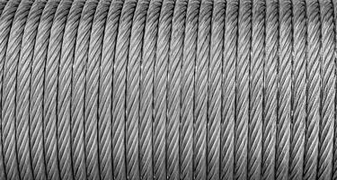 das Textur von ein Neu rostfrei Stahl Kabel eingewickelt im ein Spule. abstrakt Hintergrund. foto