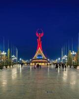 Usbekistan, Taschkent - - Januar 4, 2023 beleuchtet Monument von Unabhängigkeit im das bilden von ein Stele mit ein Humo Vogel im das Neu Usbekistan Park beim Nacht. foto