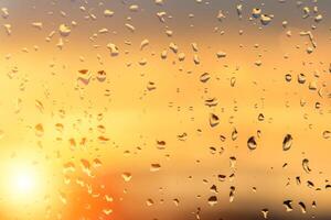 Regentropfen auf ein Fenster mit ein Sonnenuntergang Himmel im das Hintergrund. foto