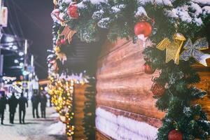 Weihnachten oder Neu Jahre Markt im ein Europa mit Häuser dekoriert mit Spielzeug Bälle und Girlanden beim Nacht. Jahrgang Film ästhetisch. foto