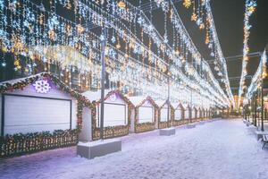 Weihnachten oder Neu Jahre Markt im ein Europa mit Häuser dekoriert mit Spielzeug Bälle und Girlanden beim Nacht. Jahrgang Film ästhetisch. foto