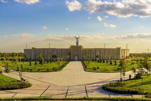 Usbekistan, Taschkent - - Oktober 4, 2023 das Gebiet von das Park Neu Usbekistan mit Monument von Unabhängigkeit im das bilden von ein Stele mit ein Humo Vogel beim Sonnenuntergang. foto