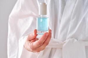 Blau Serum mit Pipette im ein Frauen Hände im ein Kleid. foto