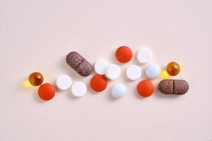 Pillen, Vitamine und Diät Ergänzungen auf ein Beige Hintergrund. foto