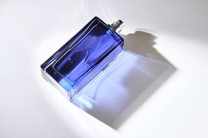 Parfüm sprühen im ein Blau Flasche auf ein Weiß Hintergrund. foto