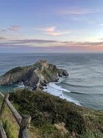 direkt am Meer beim san Juan de Gaztelugatxe im Spanien während Sonnenaufgang foto