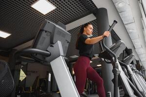 attraktiv jung Frau läuft auf ein Laufband, ist beschäftigt, verlobt im Fitness Sport Verein. foto