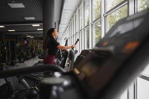 attraktiv jung Frau läuft auf ein Laufband, ist beschäftigt, verlobt im Fitness Sport Verein. foto