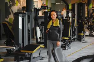 jung schön Frau Trinken Wasser im Sport Fitnessstudio. foto