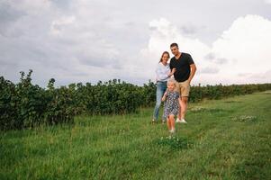 glücklich Familie mit wenig Tochter Ausgaben Zeit zusammen im sonnig Feld. foto