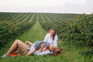 das Tochter umarmen Eltern auf Natur. Mutter, Papa und Mädchen Kleinkind, gehen im das Gras. glücklich jung Familie Ausgaben Zeit zusammen, außen, auf Urlaub, draußen. das Konzept von Familie Urlaub foto