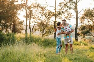 glücklich Familie von drei Personen Gehen das Gras im das Park foto