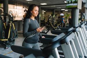 Porträt von Fitness Frau Laufen auf Laufband im Fitnessstudio Hören zu Musik.trainieren Konzept.Fitness und gesund Lebensstil foto