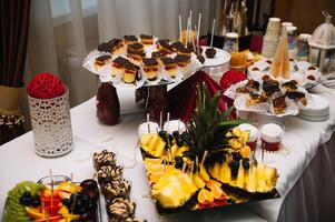 Nachspeisen mit Früchte, Mousse, Kekse. anders Typen von Süss Gebäck, klein bunt Süss Kuchen, Makronen, und andere Nachspeisen im das Süss Büfett. Süßigkeiten Bar zum Geburtstag. foto