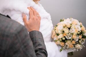 Braut steht im ein Weiß Hochzeit Kleid mit ein Strauß von Blumen foto