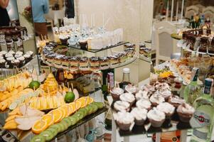 Nachspeisen mit Früchte, Mousse, Kekse. anders Typen von Süss Gebäck, klein bunt Süss Kuchen, Makronen, und andere Nachspeisen im das Süss Büfett. Süßigkeiten Bar zum Geburtstag. foto