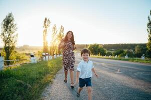 stilvoll Mutter und gut aussehend Sohn haben Spaß auf das Natur. glücklich Familie Konzept. Schönheit Natur Szene mit Familie draussen Lebensstil. glücklich Familie ruhen zusammen. Glück im Familie Leben. Mütter Tag foto