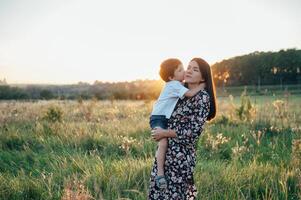 stilvoll Mutter und gut aussehend Sohn haben Spaß auf das Natur. glücklich Familie Konzept. Schönheit Natur Szene mit Familie draussen Lebensstil. glücklich Familie ruhen zusammen. Glück im Familie Leben. Mütter Tag foto