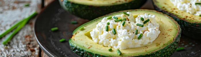 drei Avocado Hälften mit ein Weiß Käse Füllung und Grün Zwiebeln auf oben foto