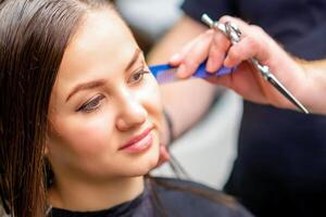 Styling weiblich Haar. männlich Friseur macht Frisur zum ein jung Frau im ein Schönheit Salon. foto