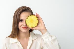 attraktiv ziemlich nett jung kaukasisch Frau halt geschnitten Ananas Abdeckung ihr Auge isoliert auf Weiß Farbe Hintergrund. foto