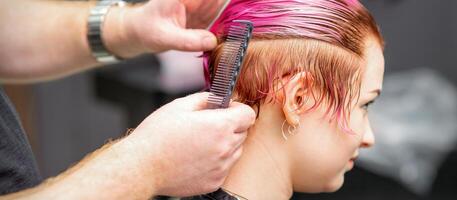 Styling weiblich Haar. männlich Friseur macht Frisur zum ein jung Frau im ein Schönheit Salon. foto