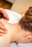 heiß Stein Massage Therapie. kaukasisch jung Frau bekommen ein heiß Stein Massage auf zurück beim Spa Salon. foto