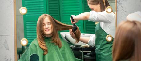 Friseur Herstellung Haar Styling zum das Frau während Kämmen mit Haarbürste, Kamm im ein Haar Salon. foto