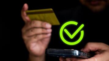 Männer ist halten das Anerkennung Karte und mit Smartphone zum Einkaufen online und bestätigen Zahlung Symbol foto