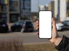 halten Handy, Mobiltelefon Telefon Bildschirm Attrappe, Lehrmodell, Simulation, leeren leer Smartphone Anzeige, verschwommen Stadt Hintergrund foto