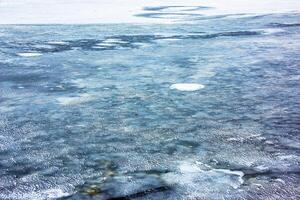 Eis Oberfläche von das Fluss. Textur von Eis Scherben und Wasser. Winter Hintergrund foto